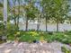 Lush backyard featuring a paver patio and garden with mature trees and plants at 8248 Sugarbush Dr, Spring Hill, FL 34606