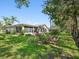 A serene backyard with lush green landscaping and a covered patio, ideal for entertaining at 8248 Sugarbush Dr, Spring Hill, FL 34606