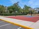 Outdoor basketball court with a vibrant red and blue playing surface at 8248 Sugarbush Dr, Spring Hill, FL 34606