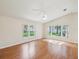 Spacious bedroom filled with natural light and featuring hardwood floors and a ceiling fan at 8248 Sugarbush Dr, Spring Hill, FL 34606