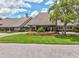Attractive clubhouse entrance with stone pillars, manicured landscaping and colorful flower beds at 8248 Sugarbush Dr, Spring Hill, FL 34606
