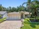 Beautiful single-story home with a brick driveway, lush landscaping, and a two-car garage at 8248 Sugarbush Dr, Spring Hill, FL 34606