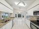 Well-lit kitchen with white cabinets, stainless steel appliances, and a breakfast nook area at 8248 Sugarbush Dr, Spring Hill, FL 34606