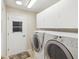 Functional laundry room featuring modern washer and dryer units, with access to the backyard at 8248 Sugarbush Dr, Spring Hill, FL 34606