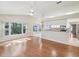 Open-concept living space featuring hardwood floors, a ceiling fan, and a view of the kitchen at 8248 Sugarbush Dr, Spring Hill, FL 34606