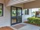Exterior of Wood Shop features double glass doors, light gray siding and green shrubbery at 8248 Sugarbush Dr, Spring Hill, FL 34606