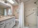 Bright bathroom featuring vanity, sink, toilet, tile floors, and shower with grab bar at 8283 Shoup St, Spring Hill, FL 34606