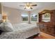 Bright bedroom featuring hardwood floors, ceiling fan, and a large dresser with mirror at 8283 Shoup St, Spring Hill, FL 34606