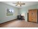 Well-lit bedroom with wood floors, ceiling fan, built-in storage, desk, and a view from the window at 8283 Shoup St, Spring Hill, FL 34606