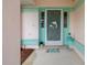 Close-up of the home's entrance featuring a decorative dolphin screen door and colorful accents at 8283 Shoup St, Spring Hill, FL 34606