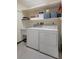 Functional laundry area with appliances, a utility sink, and built-in shelving at 8283 Shoup St, Spring Hill, FL 34606