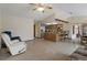 Inviting living room with tile floors, ceiling fan, and an open floorplan to the kitchen and dining area at 8283 Shoup St, Spring Hill, FL 34606