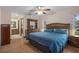 Comfortable bedroom featuring wood-look floors, ceiling fan, and an adjacent ensuite bathroom at 8283 Shoup St, Spring Hill, FL 34606