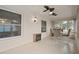 Bright sunroom with tile floors, multiple ceiling fans, windows, and furniture at 8283 Shoup St, Spring Hill, FL 34606
