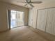 Bedroom with carpet, ceiling fan, closet and access to a screened porch at 8291 Weeping Willow St, Brooksville, FL 34613