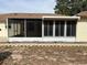 Rear view of a screened-in porch with rocks underneath at 8291 Weeping Willow St, Brooksville, FL 34613