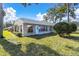 Landscaped backyard with well-kept lawn, mature trees, and partial home view at 9529 Bunker Hill Ct # 9529, New Port Richey, FL 34655