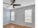 Bedroom featuring laminate floors, a ceiling fan, and two windows with blinds at 9529 Bunker Hill Ct # 9529, New Port Richey, FL 34655