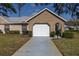 Front exterior of home featuring a 2 car garage, driveway and tidy shrubbery at 9529 Bunker Hill Ct # 9529, New Port Richey, FL 34655