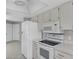 Bright kitchen features white appliances, white cabinets, and tiled backsplash at 9529 Bunker Hill Ct # 9529, New Port Richey, FL 34655