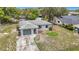 Aerial view of a charming single-story home with a driveway and mature trees at 10139 Carrin Rd, Spring Hill, FL 34608