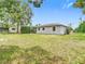Large backyard showcasing the home's exterior and well-maintained lawn at 10139 Carrin Rd, Spring Hill, FL 34608