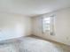 Bedroom with a window covered by patterned curtains, neutral walls, and neutral carpeting at 10139 Carrin Rd, Spring Hill, FL 34608