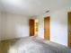 Bedroom with neutral walls, neutral carpeting, wood closets, and door to the kitchen at 10139 Carrin Rd, Spring Hill, FL 34608