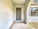 The entryway features a secure metal gate and a textured exterior wall at 10139 Carrin Rd, Spring Hill, FL 34608