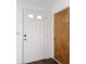 Entryway features a white front door with glass panes and a wood-paneled interior door at 10139 Carrin Rd, Spring Hill, FL 34608
