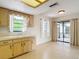 Bright kitchen with a sink under a window, wooden cabinets, and a glass door to the outside patio at 10139 Carrin Rd, Spring Hill, FL 34608