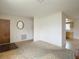 Neutral living room showing entry door, carpet, and view to kitchen beyond at 10139 Carrin Rd, Spring Hill, FL 34608