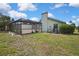 Backyard view of the home with screened-in pool and lush landscaping at 10277 Rosetti Ct, Spring Hill, FL 34608