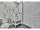 Bathroom features marble tile, vanity and an enclosed closet with white folding doors at 10277 Rosetti Ct, Spring Hill, FL 34608