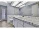 Bathroom features a large mirror, bright lighting, marble counters and white cabinets at 10277 Rosetti Ct, Spring Hill, FL 34608