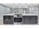 Kitchen island boasts stainless oven, microwave, storage, white countertop and stylish pendant lighting above at 10277 Rosetti Ct, Spring Hill, FL 34608