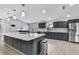 Modern kitchen featuring an island, stainless steel appliances, gray cabinets, and bright lighting at 10277 Rosetti Ct, Spring Hill, FL 34608