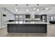 This spacious kitchen features an oversized island, gray cabinetry, stone countertops, and stainless appliances at 10277 Rosetti Ct, Spring Hill, FL 34608
