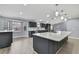 Open-concept kitchen features a large island, stainless appliances, stone countertops, stylish pendant lighting and gray cabinetry at 10277 Rosetti Ct, Spring Hill, FL 34608