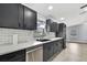 Modern kitchen with gray cabinets, stainless steel appliances, and white subway tile backsplash at 10277 Rosetti Ct, Spring Hill, FL 34608