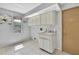 Bright laundry room featuring tiled floor, utility sink with storage, and window with natural light at 10277 Rosetti Ct, Spring Hill, FL 34608
