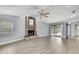 Bright living room with brick fireplace, ceiling fan, and sliding glass doors to the pool at 10277 Rosetti Ct, Spring Hill, FL 34608