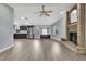 Open living area with brick fireplace and opening into kitchen with stainless appliances and gray cabinets at 10277 Rosetti Ct, Spring Hill, FL 34608