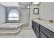 Bathroom showcasing a spa-like tub, step in shower, and dual sinks at 10277 Rosetti Ct, Spring Hill, FL 34608