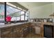 Outdoor kitchen with stone accents, sink, and built-in mini-fridge at 10277 Rosetti Ct, Spring Hill, FL 34608