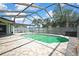 Screened-in pool with stone tile patio and palm trees at 10277 Rosetti Ct, Spring Hill, FL 34608
