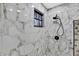 Shower with black hardware, marble tile surround, and pebble floor at 10277 Rosetti Ct, Spring Hill, FL 34608