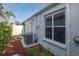 Exterior view of the home showcasing the air conditioning unit, window, and door to the backyard at 1084 Vista Fina Ct, Spring Hill, FL 34608