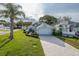 A bright single-Gathering home featuring manicured landscaping, a long brick driveway, and a two-car garage at 1084 Vista Fina Ct, Spring Hill, FL 34608