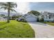 A bright single-Gathering home featuring manicured landscaping, a long brick driveway, and a two-car garage at 1084 Vista Fina Ct, Spring Hill, FL 34608